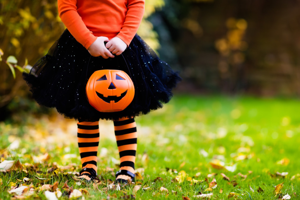 child holding a pumpkin basket