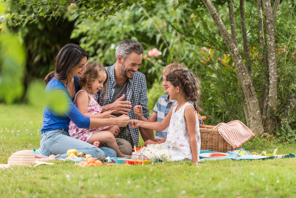 family with three kids having a picnic outdoors