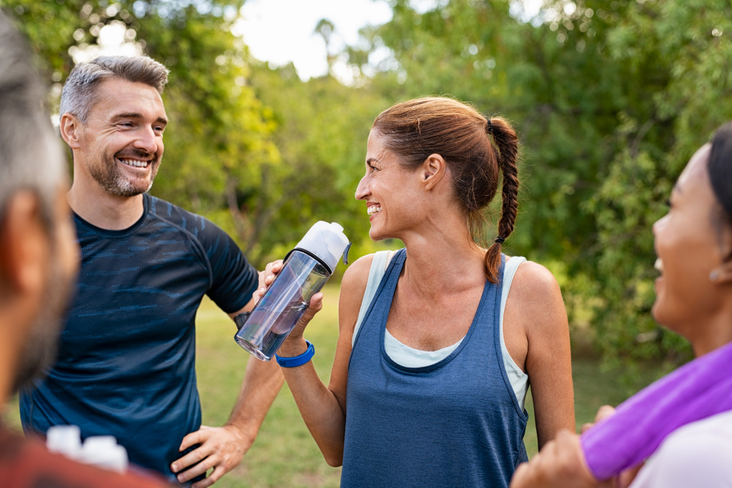 a woman rehydrating with a water bottle