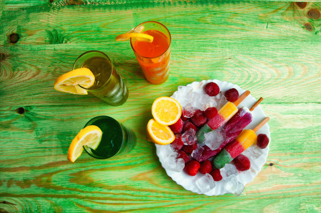 fruit skewers in a plate with ice and drinks on the side