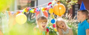 active outdoors party with happy children in party hats