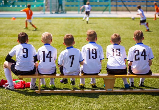 kids on the bench playing soccer