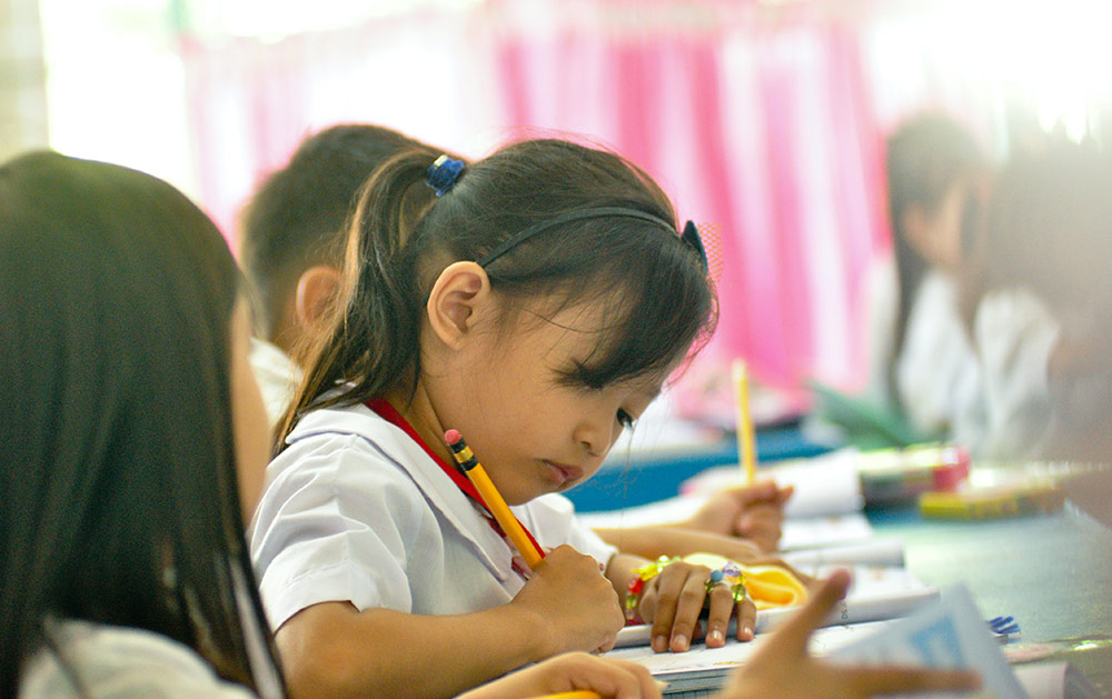 kid writing using a pencil