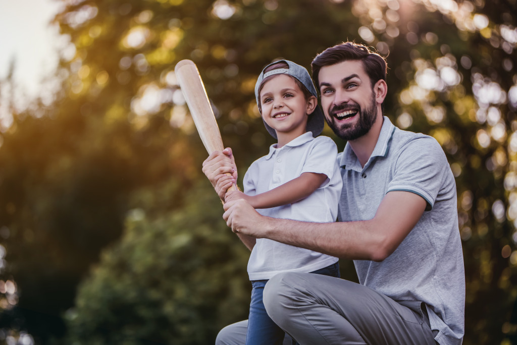 father and son holding a baseball bat